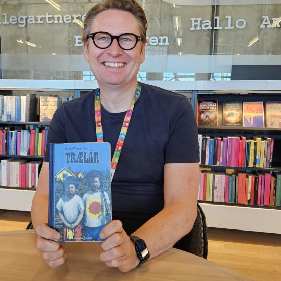 Foto af bibliotekar Bjørn med en bog i hånden